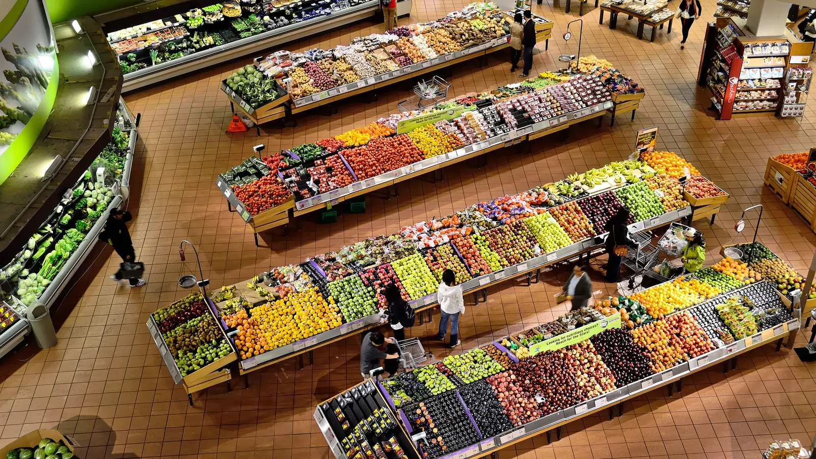 Rayons de fruits et légumes d'un commerce de proximité vus depuis la mezzanine