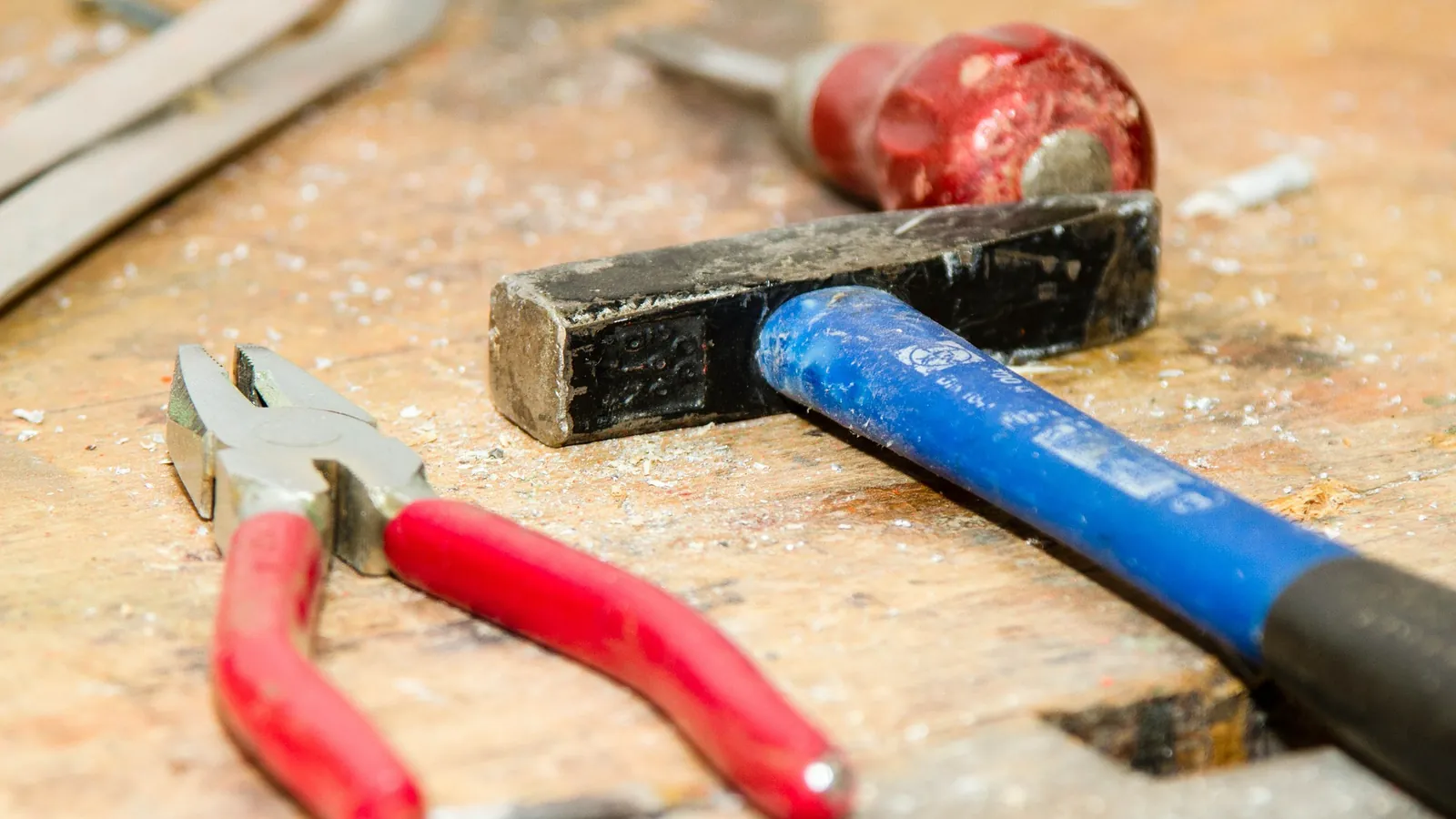 Marteau, pince coupante et tournevis posés sur l'établi d'un artisan du bâtiment