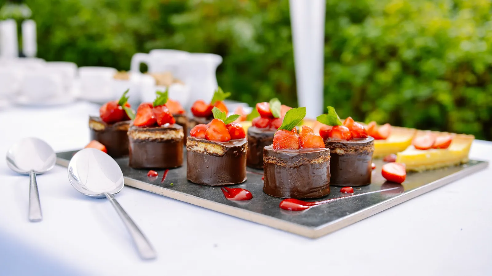 Plateau de desserts au chocolat et aux fraises dressé sur un buffet de traiteur