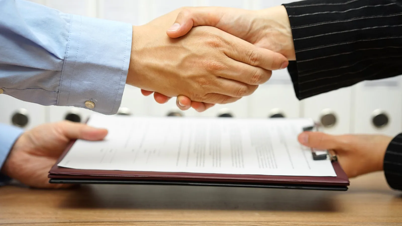 Cédant et repreneur signant les documents d'une cession d'entreprise dans le Nord