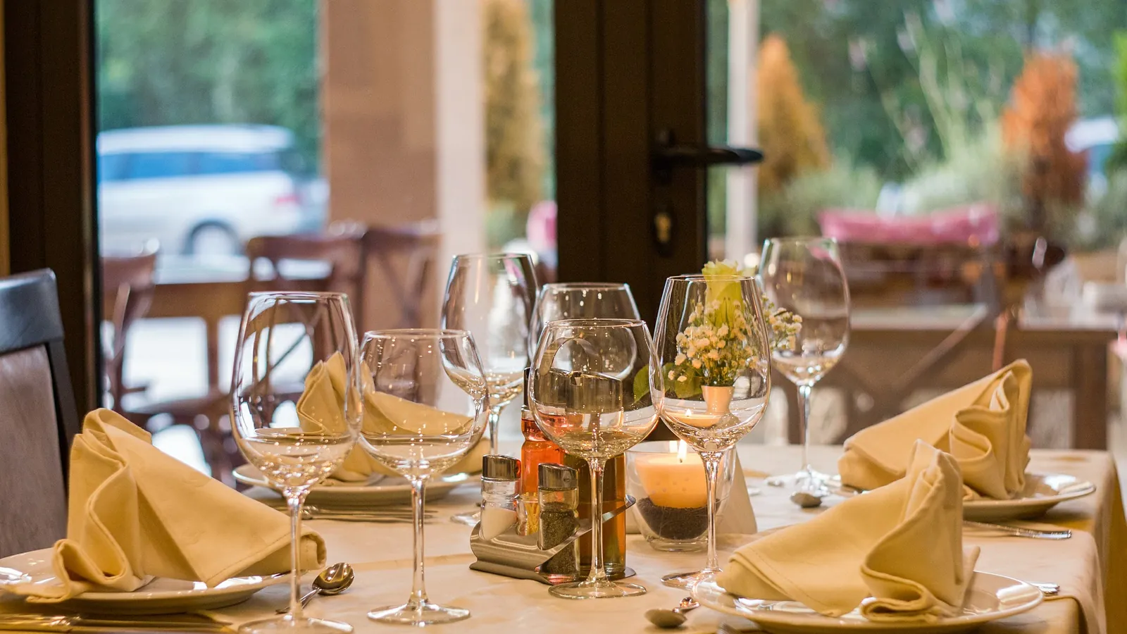 Salle de restaurant, table dressée avec ses verres à pied et ses serviettes pliées