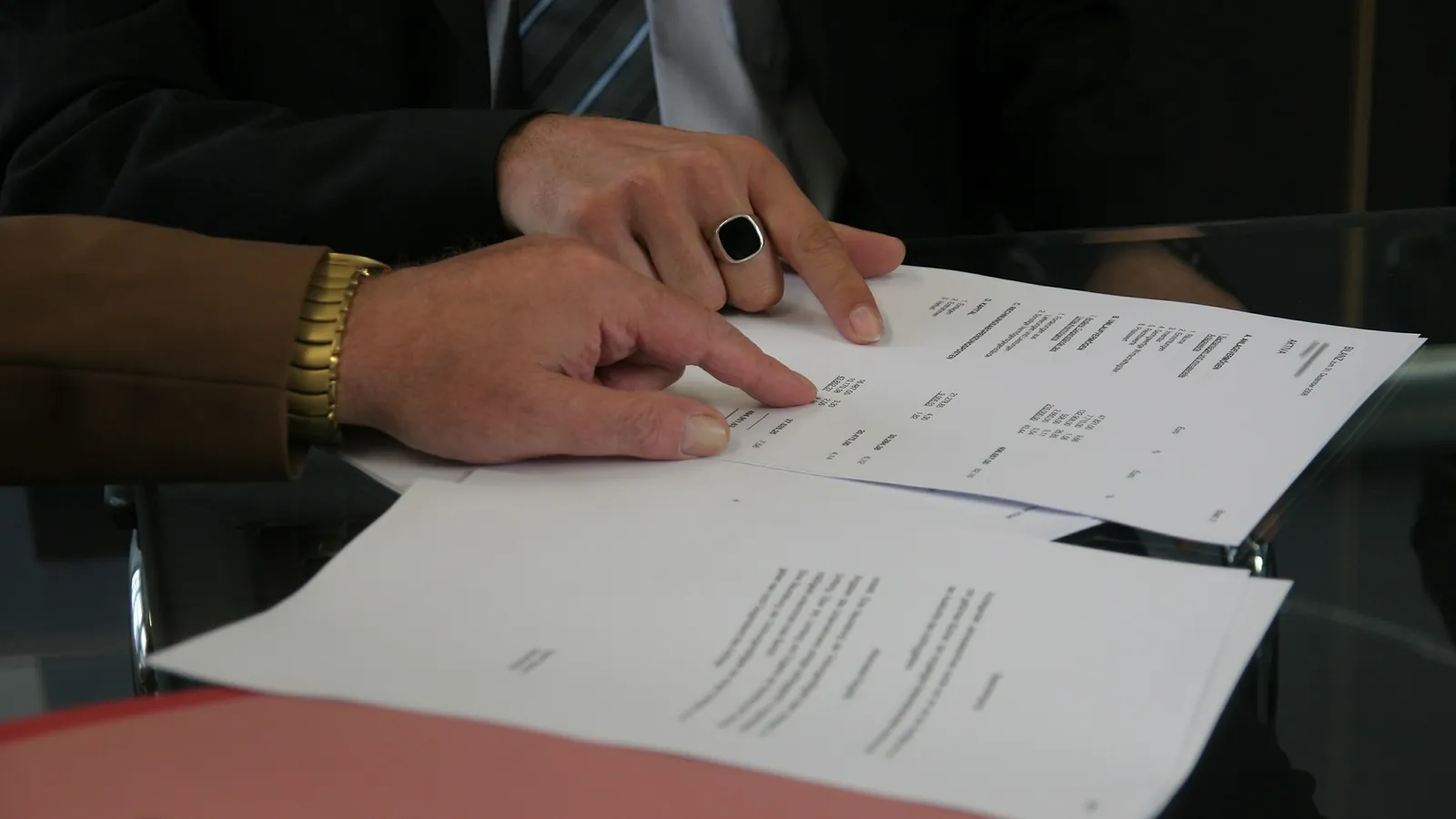 Mains d'un dirigeant parcourant un devis papier avant de relancer son client
